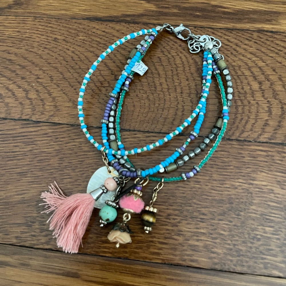 Beaded bracelet in blue with fringe decoration and charms